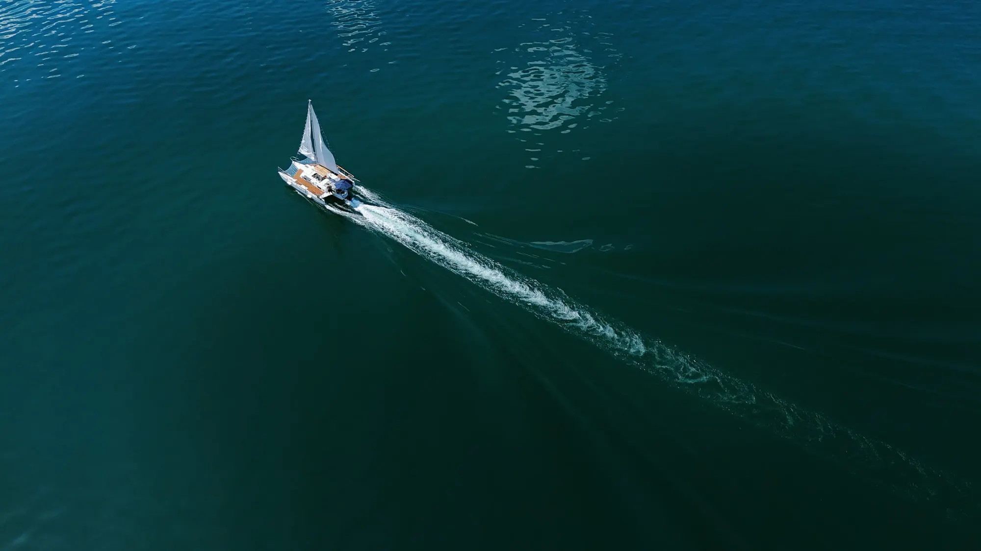A small sailboat under way on Lago de Coatepeque, seen from above